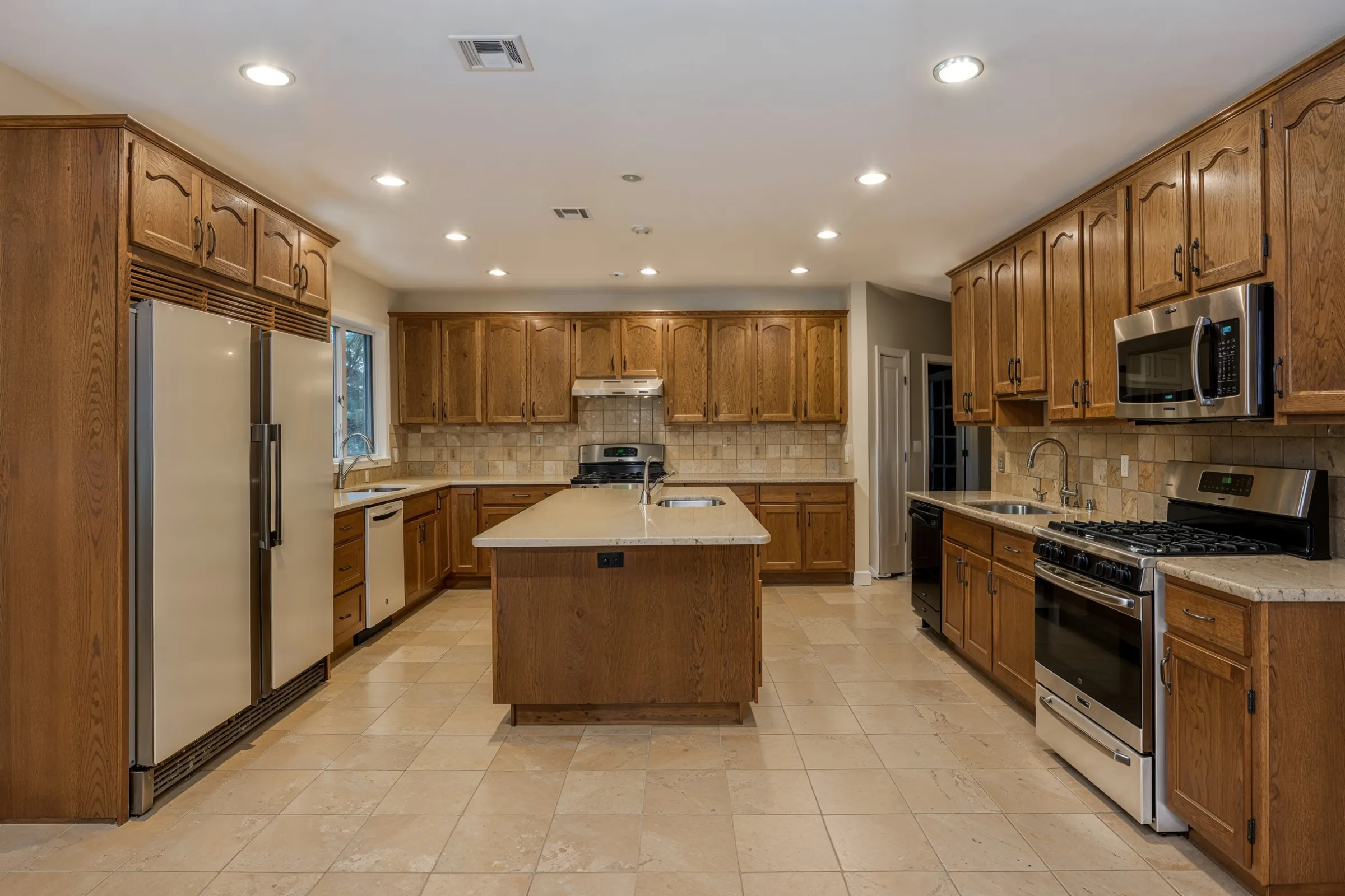 Before kitchen remodeling project in Los Angeles showing outdated wood cabinets, older tile flooring, traditional backsplash, limited storage, and dated kitchen layout