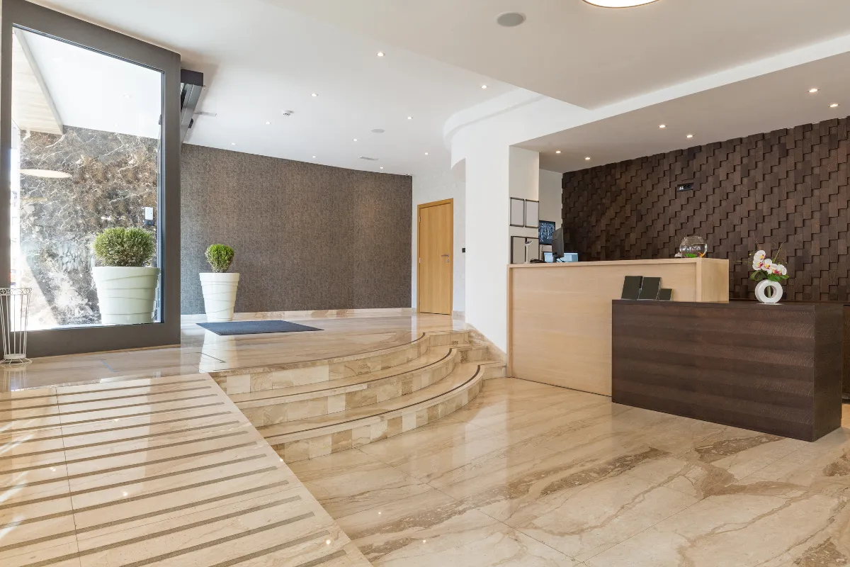 Commercial remodeling project in Los Angeles with modern lobby renovation, reception desk, marble flooring, accent wall, lighting, and professional business interior