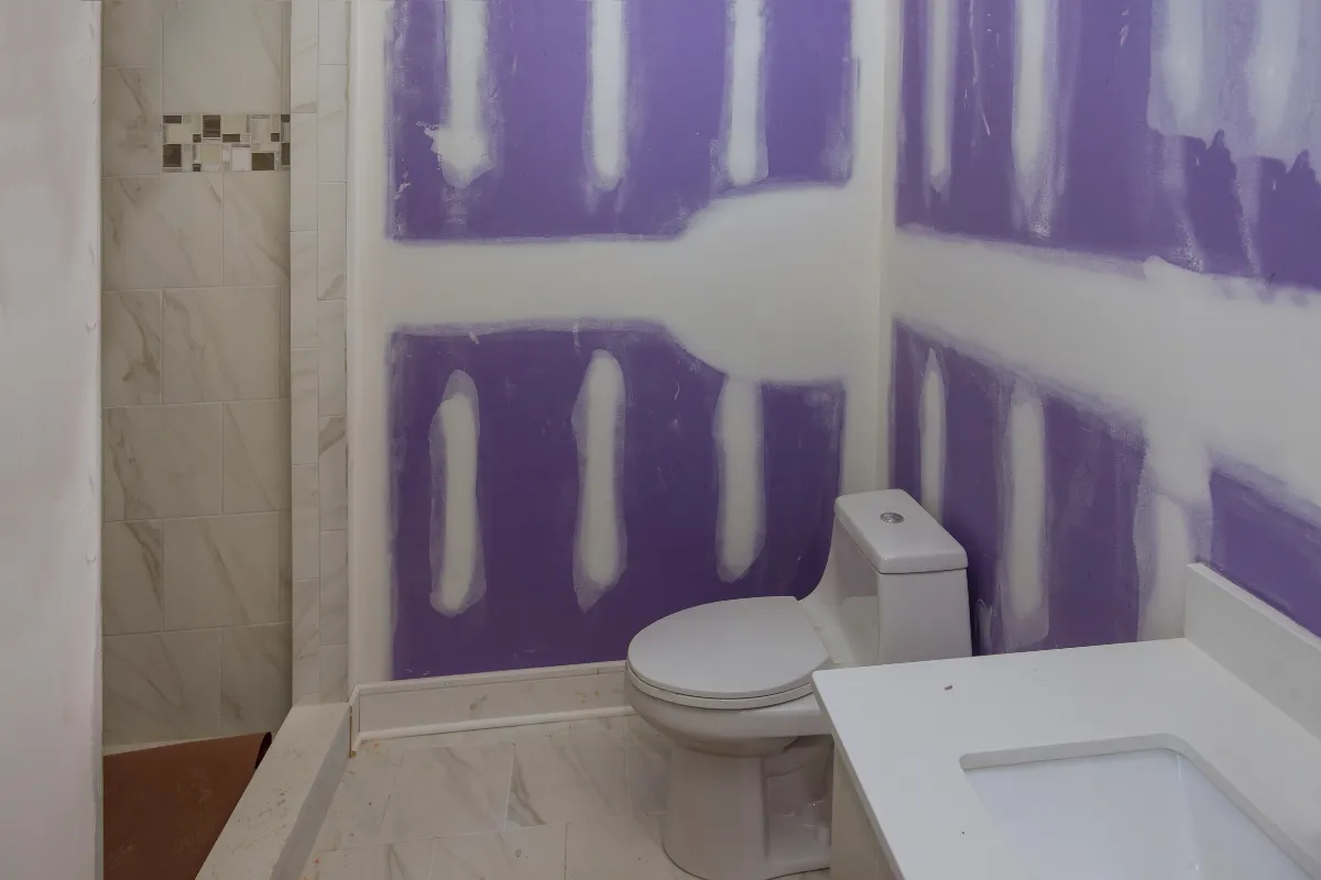 Bathroom remodeling in Los Angeles with drywall finishing, tile installation, vanity area, toilet setup, and shower renovation in progress