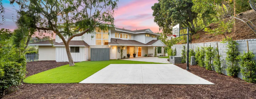 Completed backyard remodeling project in Los Angeles with modern landscaping, artificial turf, concrete patio, sport court, retaining wall, and outdoor living space