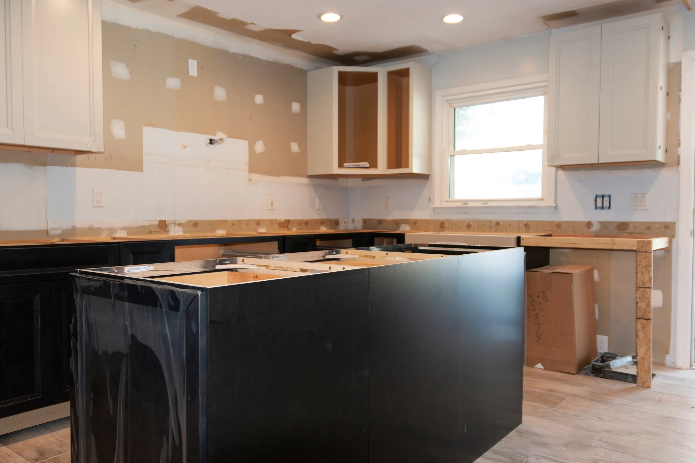 Kitchen remodeling in Los Angeles with cabinet installation, island construction, wall preparation, and interior renovation work in progress