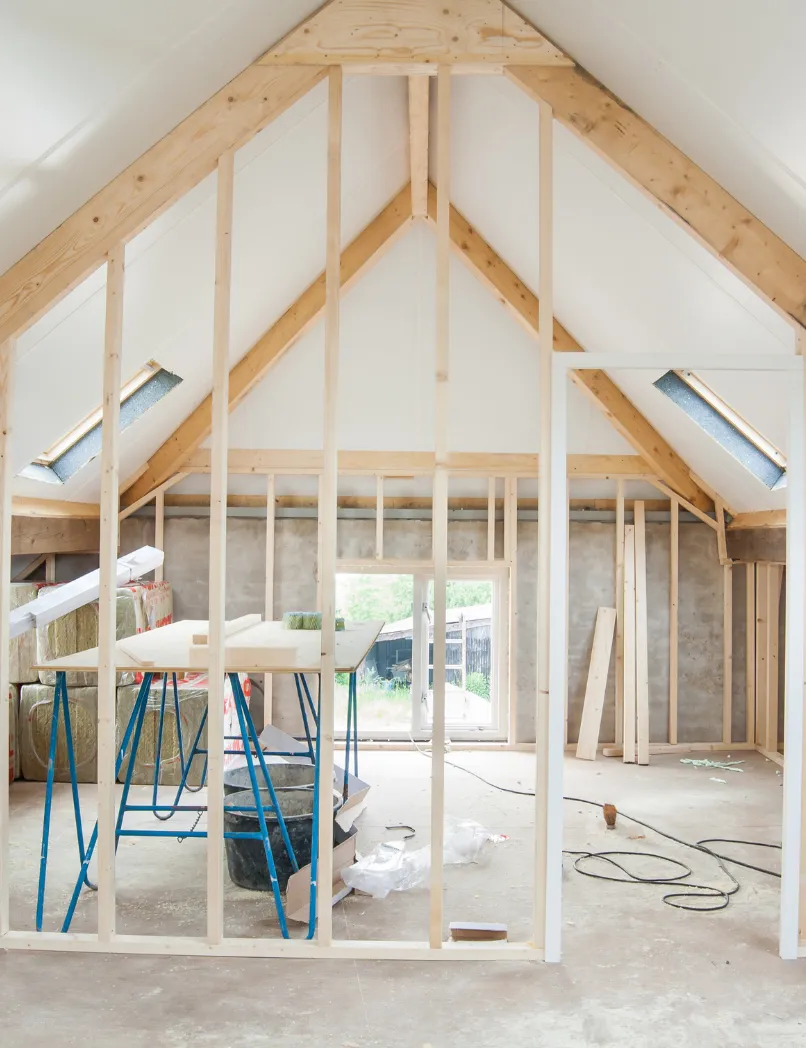 Room addition construction in Los Angeles with interior wall framing, vaulted ceiling structure, skylights, and home expansion work in progress