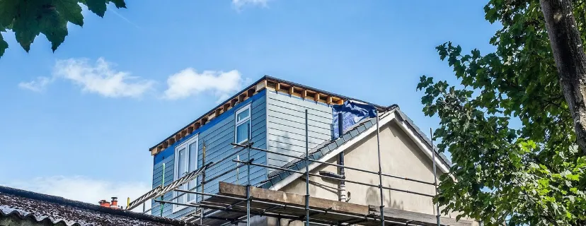 Second-story room addition in Los Angeles with exterior framing, scaffolding, siding installation, and home expansion construction in progress